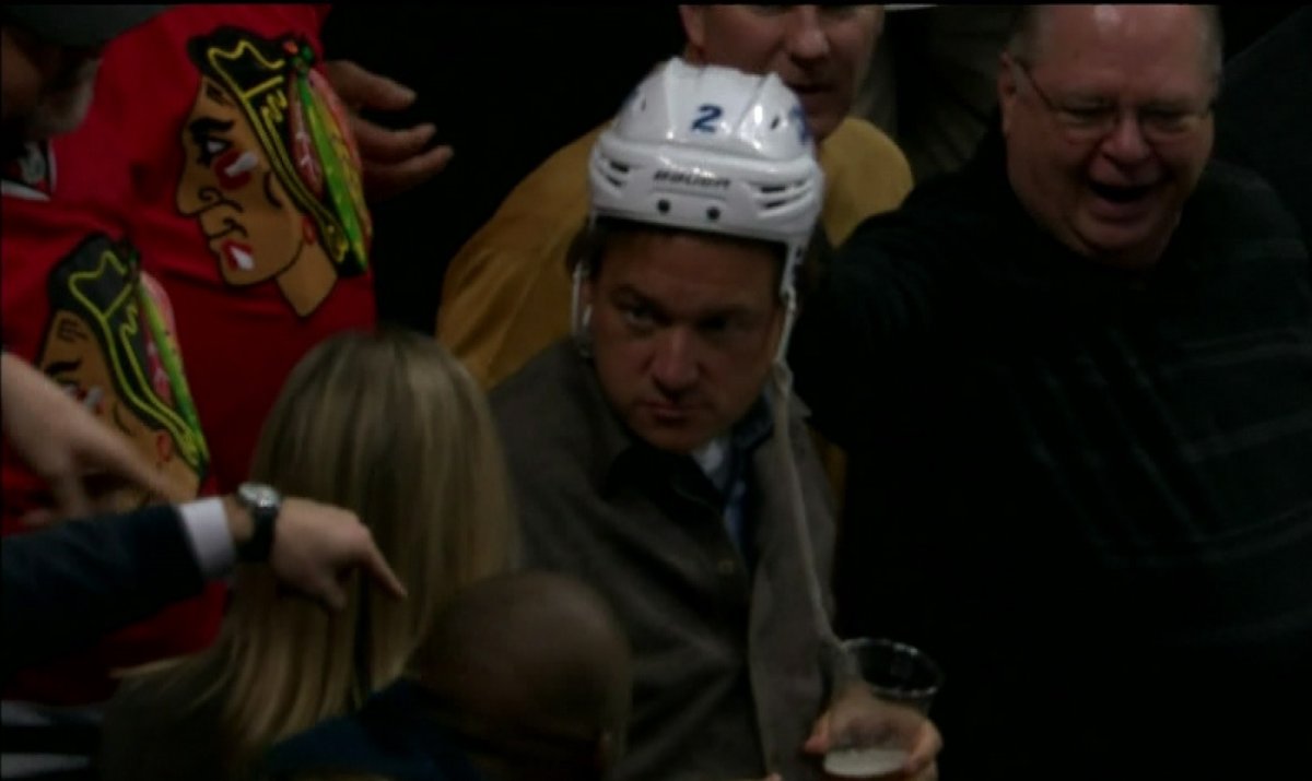 A Chicago fan wears Adam Pardy's helmet after ripping it from the defenceman's head during a game.