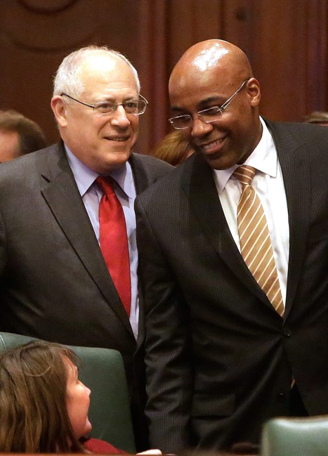 Illinois Gov. Pat Quinn, left, and Illinois Sen. Kwame Raoul, D-Chicago, right, look on as gay marriage legislation passes on the House floor during veto session Tuesday, Nov. 5, 2013 in Springfield Ill. 