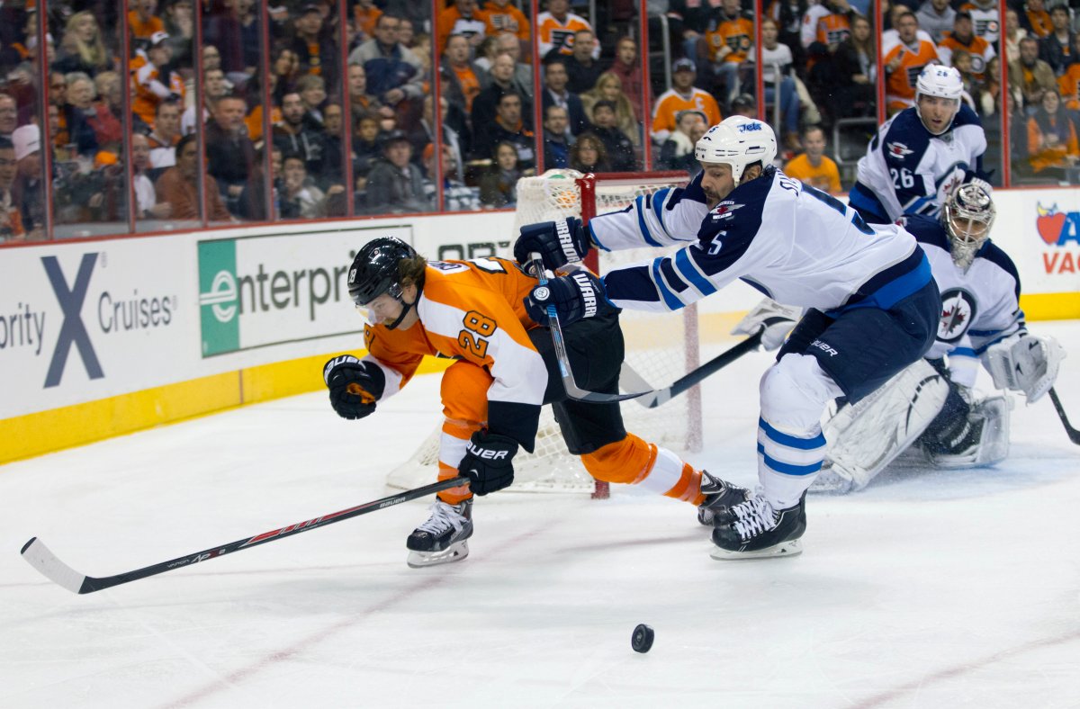 Philadelphia Flyers' Claude Giroux, (28) gets pushed out of the way by Winnipeg Jets' Mark Stuart as he tried to shoot the puck at Ondrej Pavelec, of Czech Republic, right, during the second period of an NHL hockey game, Friday, Nov. 29, 2013, in Philadelphia. 