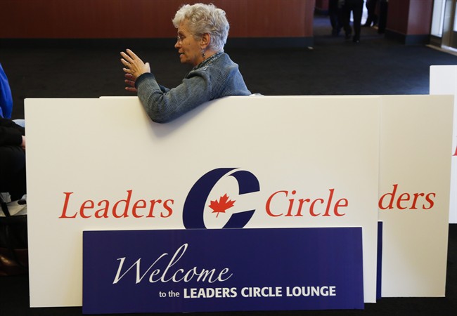 A delegate leans on a sign as people gather at the Conservative convention in Calgary, Oct. 31, 2013.