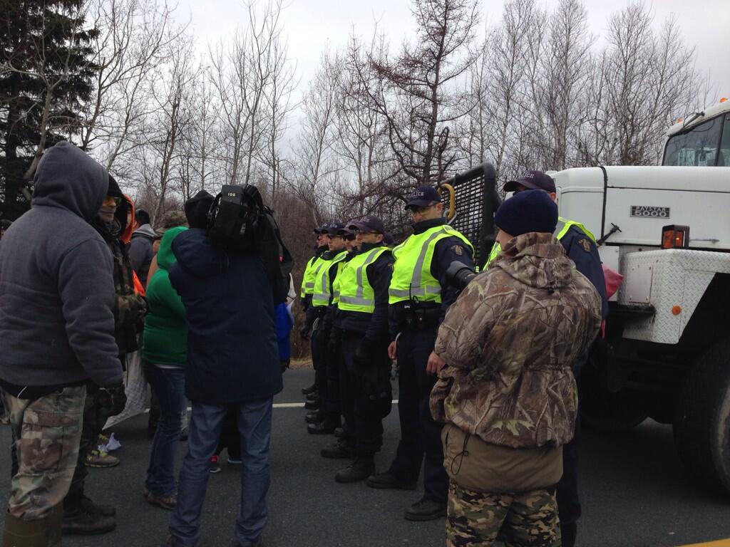 RCMP officers form a line between protesters and SWN Resources seismic testing trucks near Laketon, N.B. on Nov. 14, 2013.