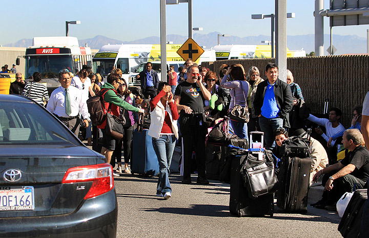 Passengers evacuate the Los Angeles International Airport on Friday Nov. 1, 2013, in Los Angeles. Shots were fired at Los Angeles International Airport, prompting authorities to evacuate a terminal and stop flights headed for the city from taking off from other airports.