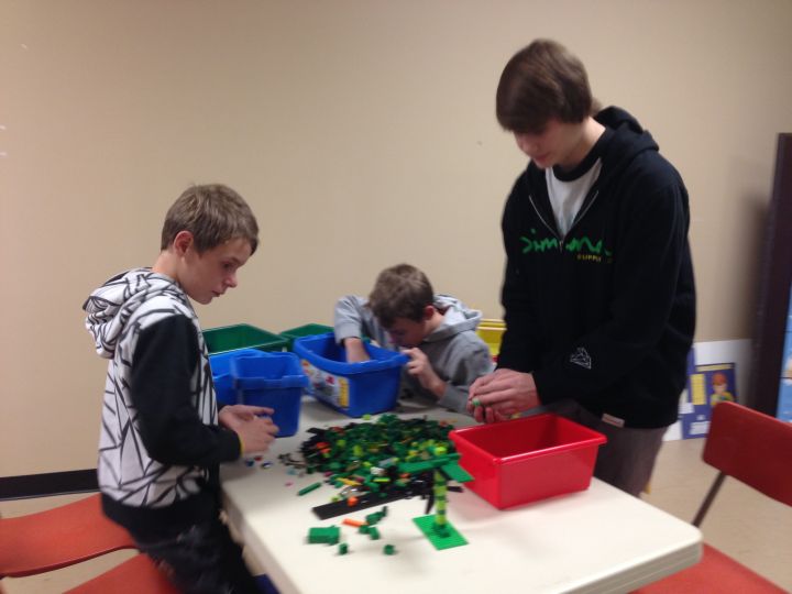 Tyler and Tyson Burns interact with their teenage leader at Lego Therapy.