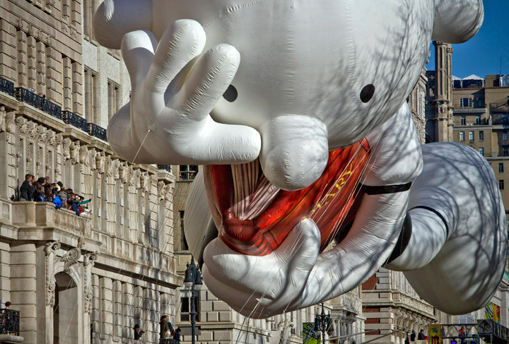 Residents in an apartment block watch as giant balloons float past during the Macy’s Thanksgiving Day Parade on November 28, 2013 in New York City. (Photo credit: Getty Images)