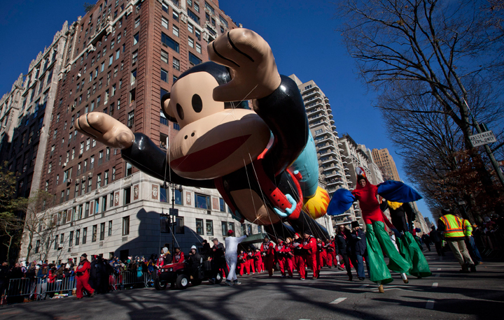 Performers walk alongside giant floating balloons during the Macy’s Thanksgiving Day Parade on November 28, 2013 in New York City. (Photo credit: Getty Images)