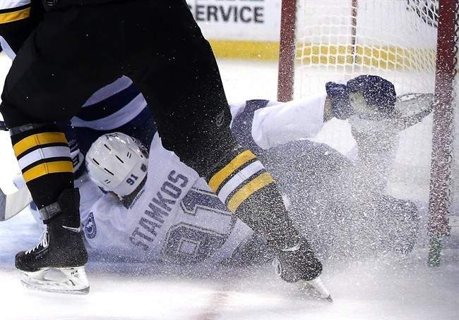Tampa Bay Lightning center Steven Stamkos holds his skate after banging into the goalpost defending against Boston Bruins defenseman Dougie Hamilton, above, during the second period of an NHL hockey game in Boston Monday, Nov. 11, 2013. Stamkos was taken off the ice on a stretcher after the play.