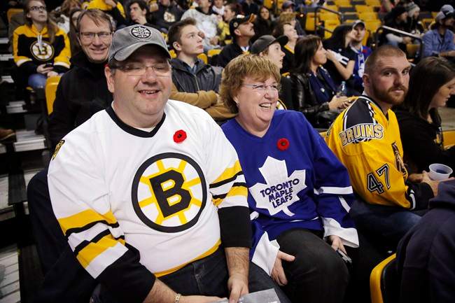 Tracy MacKenzie, left, and his wife Kim, from Nova Scotia, wait for the start of an NHL hockey game between the Boston Bruins and the Toronto Maple Leafs in Boston, Saturday, Nov. 9, 2013. (AP Photo/Michael Dwyer).