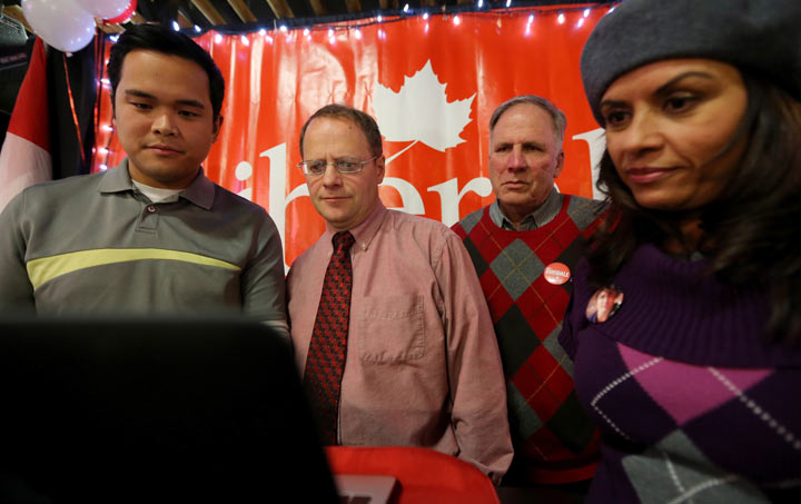 Roldan Sevillano, Executive Assistant to Kevin Lamoureux, MP Winnipeg North, Kevin Lamoureux, Stan Tataryn President of the Liberal Party of Canada Manitoba, and Sandy Chahal, Election Readiness Committee Co-Chair, all closely monitor results at Rolf Dinsdale's reception headquarters, in Brandon, Man., Monday night, Nov. 25, 2013. THE CANADIAN PRESS/Trevor Hagan.