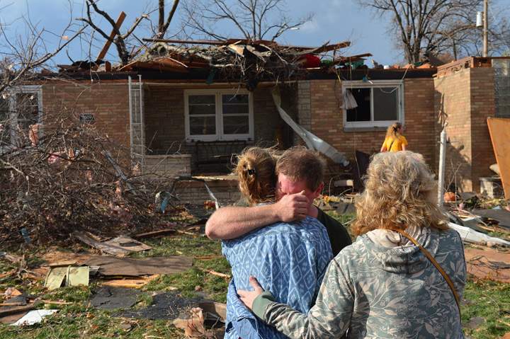 Ray Baughman embraces family shortly after his home was destroyed by a tornado that left a path of devastation through the north end of Pekin, Il., Sunday, Nov. 17, 2013.  (Photo credit: AP Photo)