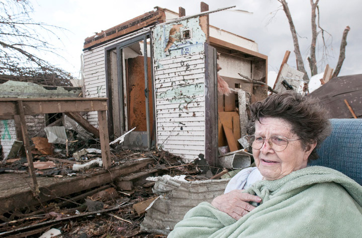 Pat Whitaker, 82, sits under a blanket in her nightgown outside her home waiting for help to come in Gifford, Ill. on Sunday, Nov. 17, 2013. (Photo credit: AP Photo)