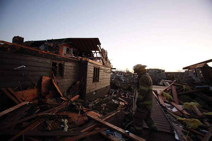 A firefighter searches through debris after a tornado struck on November 17, 2013 in Washington, Illinois.