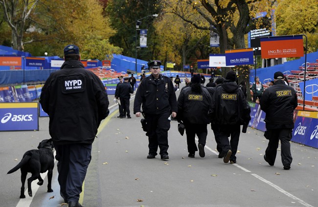 Security personnel walk near the finish line of the 2013 New York City Marathon in New York, Sunday, Nov. 3, 2013. The increased security at the marathon will be most evident near the finish line in Central Park. There will be barricades around the park to limit entry points, bag checks and bomb-sniffing dogs. (AP Photo/Seth Wenig).