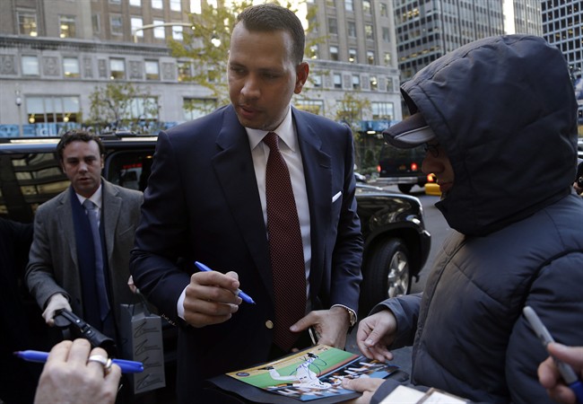 Alex Rodriguez signs autographs as he arrives at Major League Baseball headquarters in New York, Tuesday, Nov. 19, 2013.