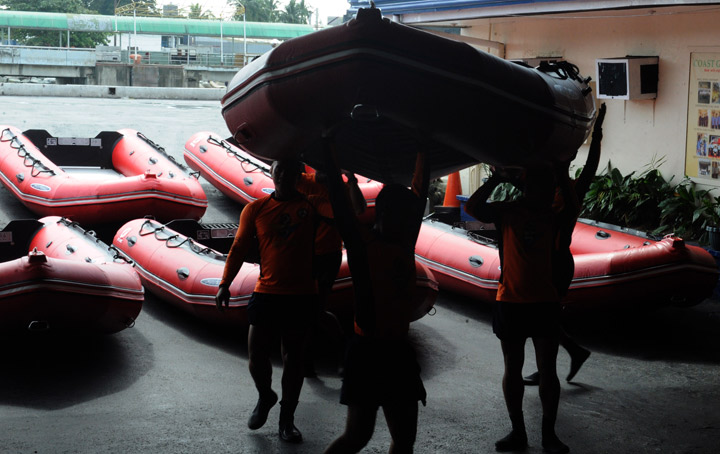 Fisherman repair there outrigger on the shore of Manila bay as Typhoon Haiyan approached on November 7, 2013. (Photo credit: Getty Images)