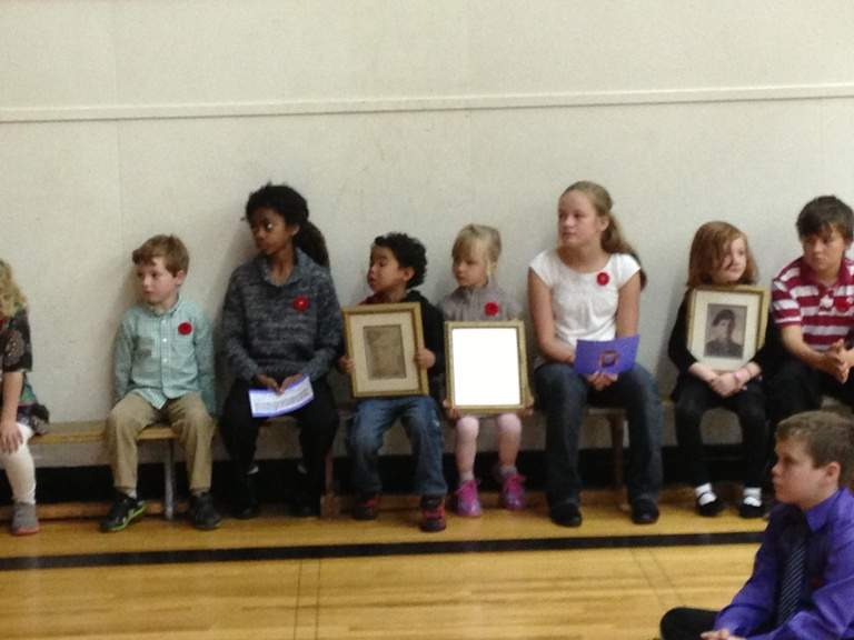 Students carry the portraits and wait to speak about the fallen soldiers.