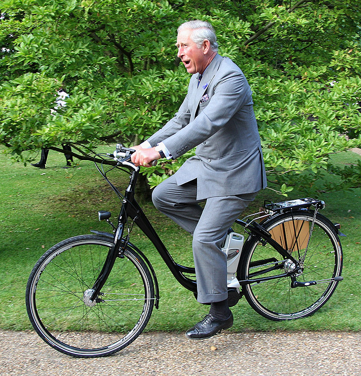 Prince Charles, Prince of Wales rides an eco-bike as he attends a preview of Start Day which features exhibits from the Earth Awards at Clarence House on July 27, 2011 in London, England. (Photo credit: Getty Images)