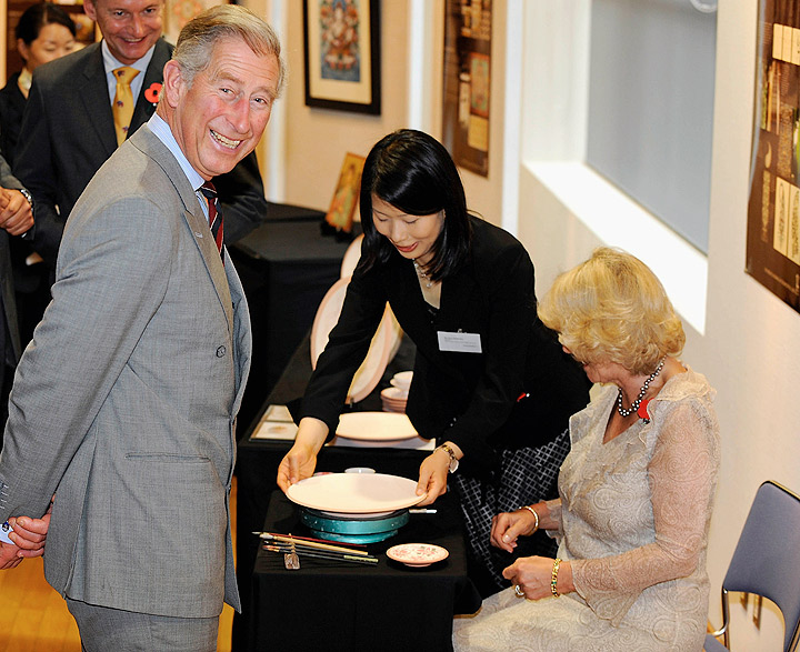 Prince Charles, Prince of Wales and TRH Camilla, Duchess of Cornwall attempt to autograph on a plate at a calligraphy gallery by Japanese artists who graduated Britain’s art school ‘The Prince’s School of Traditional Arts’ during their visit at Nara Craft Museum on October 29, 2008. (Photo credit: Getty Images)