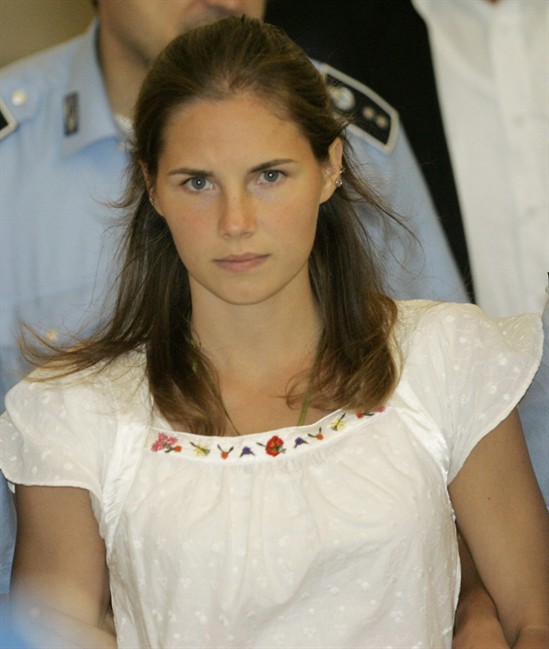 FILE - In this Tuesday Sept. 16, 2008 file photo, Amanda Knox is escorted by Italian penitentiary police officers from Perugia's court after a hearing, central Italy. 