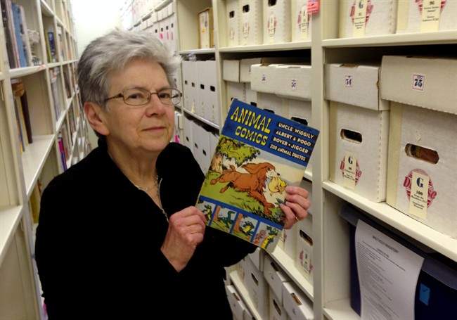 In this Nov. 7, 2013 photo Maggie Thompson poses with "Animal Comics" in the addition she added to her Wisconsin home to house her tens of thousands of comic books. Thompson has put about 500 of her most treasured issues up for auction, including copies of "Journey Into Mystery" No. 83, the first appearance of Thor, and the first issue of "The Avengers." (AP Photo/Todd Richmond).