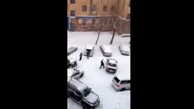 Several motorists attempt to stop cars from sliding down a slippery road in Khabarovsk, Russia.