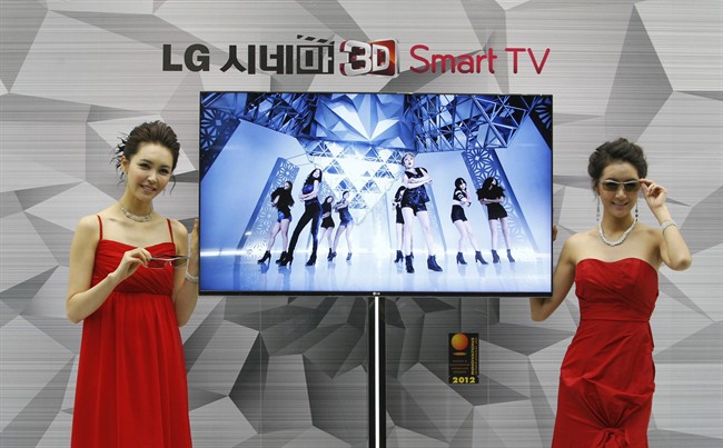 South Korean models pose with a CINEMA 3D Smart TV during a press conference to introduce the LG Electronics' television.