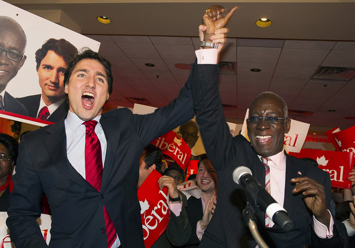Liberal Leader Justin Trudeau, left, raises the arm of Emmanuel Dubourg in Montreal, Monday, November 25, 2013 following Dubourg's win in federal byelection for the riding of Bourassa. THE CANADIAN PRESS/Graham Hughes.