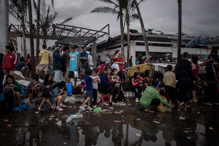 Typhoon victims wait to be evacuated at the airport in Tacloban, on the eastern island of Leyte on November 12, 2013 after Super Typhoon Haiyan swept over the Philippines. 