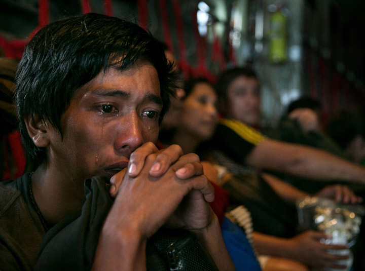  A man sits crying on a packed C130 aircraft as emotions take over after he and hundreds of other victims of super Typhoon Haiyan are evacuated from the area on November 12, 2013 in Tacloban, Philippines.