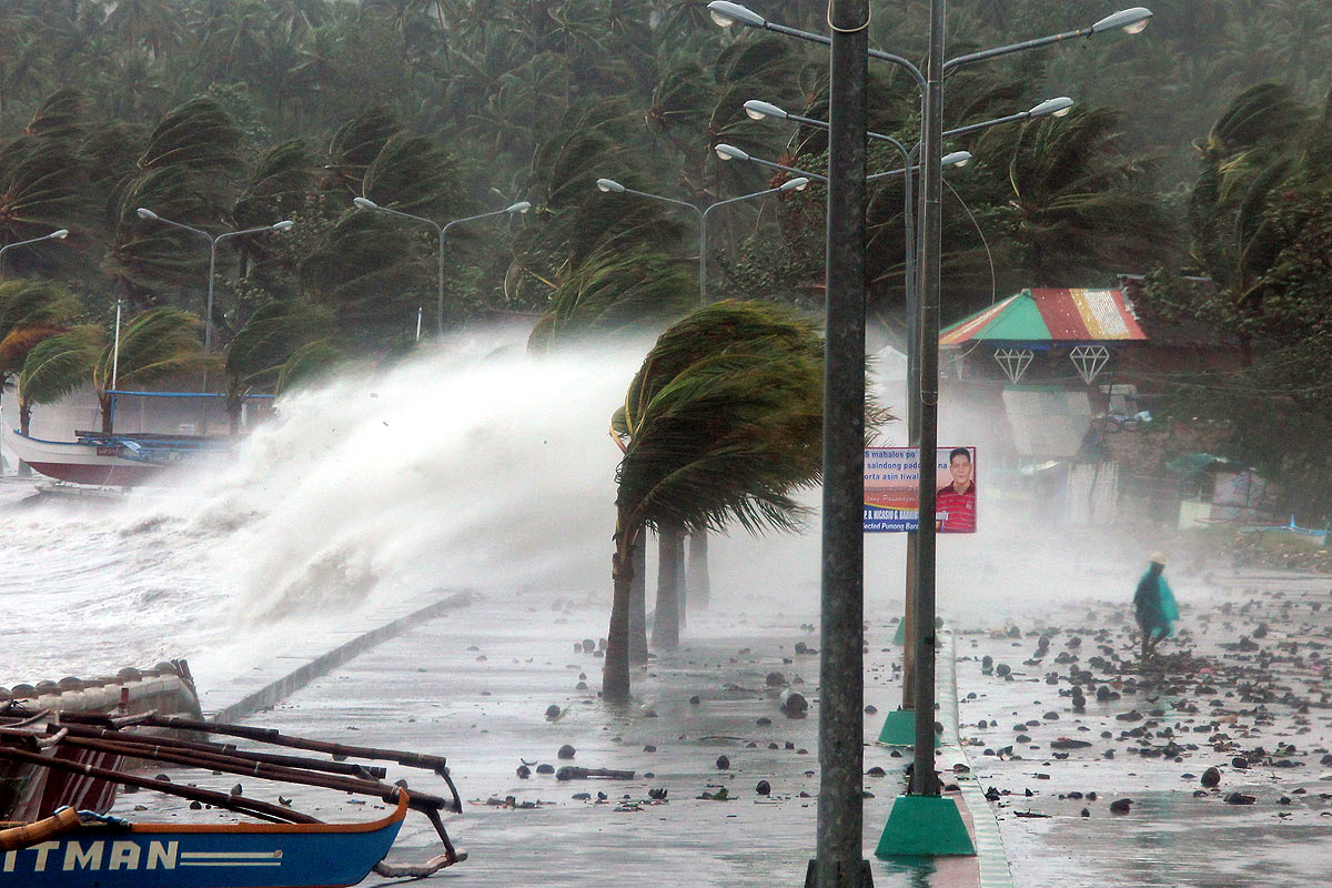One of the most intense typhoons on record whipped the Philippines on November 8, killing three people and terrifying millions as monster winds tore roofs off buildings and giant waves washed away flimsy homes. (Charism Sayat/AFP/Getty Images)