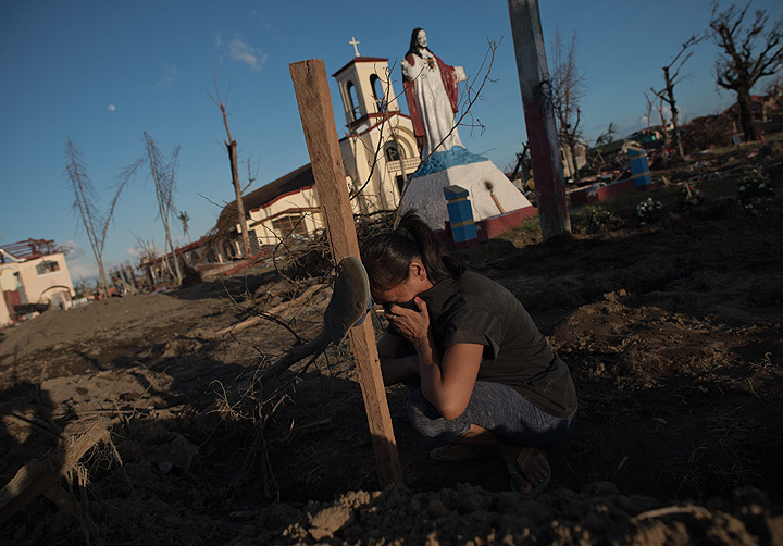 Marelom Cassanares, 37, with five children and no home cries at the grave of her husband in the aftermath of Super Typhoon Haiyan in Palo, the outskirts of Tacloban on November 15, 2013. 