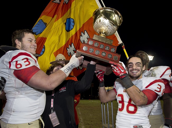 Laval Rouge et Or Pierre Lavertu, left, and Vincent Plante hold the Uteck Bowl after defeating the Mount Allison Mounties 48-21 in university football on Nov. 16. Lavertu is being eyed by both the Ottawa Redblacks and Winnipeg Blue Bombers in the CFL draft.