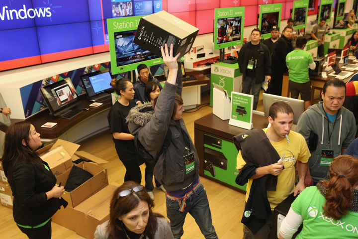An excited fan shows off his new Xbox One after purchasing it at midnight from the Microsoft retail store in Fashion Valley Mall in San Diego, California.