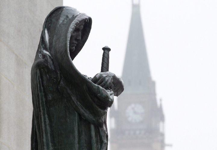A statue representing Justice is seen in front of the Supreme Court building in Ottawa. 