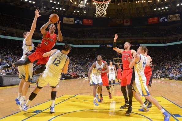 DeMar DeRozan #10 of the Toronto Raptors shoots against Klay Thompson #11 and Andrew Bogut #12 of the Golden State Warriors on December 3, 2013 at Oracle Arena in Oakland, California. 