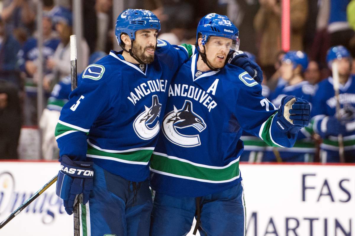 Daniel Sedin celebrates with Jason Garrison after scoring a power play goal against the Edmonton Oilers during the second period. (Photo by Rich Lam/Getty Images).