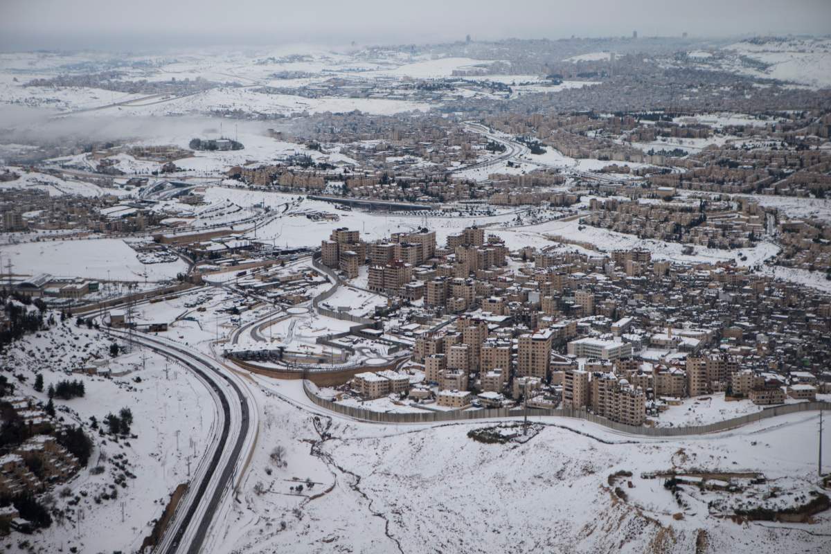 EAST JERUSALEM, WEST BANK - DECEMBER 14: (ISRAEL OUT) Israel's separation barrier sits covered with snow on December 14, 2013 at the West Bank outskits of Jerusalem.Heavy storms continued throughout Israel on Saturday, causing traffic disruptions and power outages across the country. (Photo by Uriel Sinai/Getty Images)