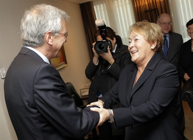 Quebec Premier Pauline Marois, right, is welcomed by Flanders Minister-President Kris Peeters at his office in Brussels, Monday, Dec. 16, 2013. (AP Photo/Yves Logghe).