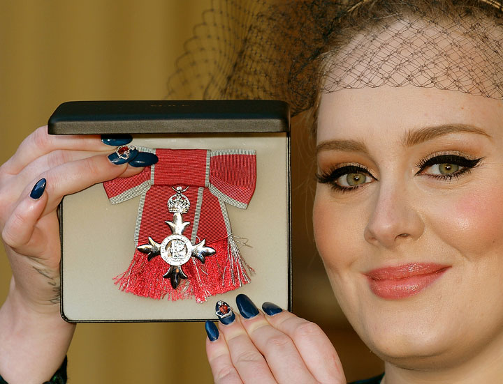 Singer Adele displays the award she received from Prince Charles.