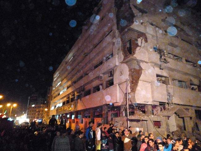 Egyptians gather after a powerful explosion believed to be caused by a car bomb rocked a police headquarters in the Nile Delta city of Mansoura, 110 kilometers (70 miles) north of Cairo north of Cairo early on Tuesday, killing more than a dozen people. 