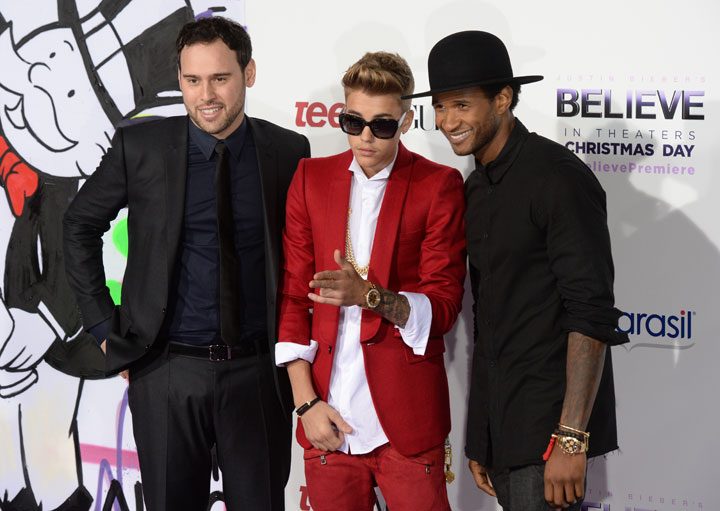Justin Bieber, flanked by Scooter Braun and Usher, pictured in December 2013.