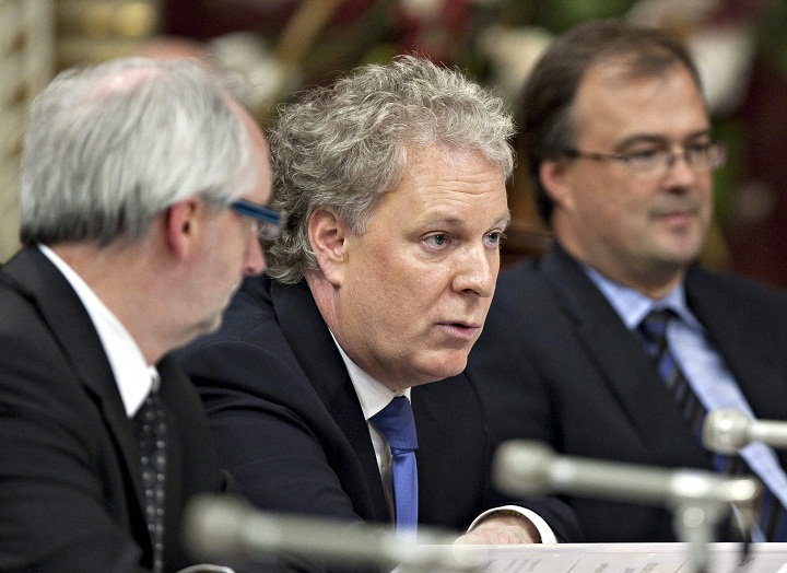 Quebec Premier Jean Charest appears before a legislature committee, flanked by his chief of staff Marc Croteau, left, and Gerard Bibeau, secretary general of the executive council, to defend his office department's spending Monday April 26, 2010 at the legislature in Quebec City.
