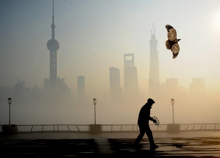 A man flies a kite at The Bund on December 5, 2013 in Shanghai, China. Heavy smog continued to hit northern and eastern parts of China on Thursday, disturbing the traffic, worsening air pollution and forcing the closure of schools.  