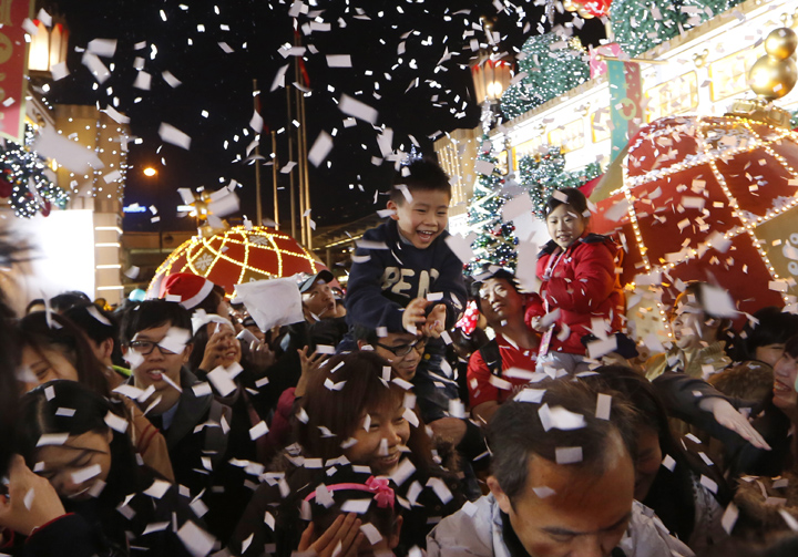 Visitors play with shredded paper and Christmas decorations during Christmas eve at a shopping mall in Hong Kong,Tuesday, Dec. 24, 2013.