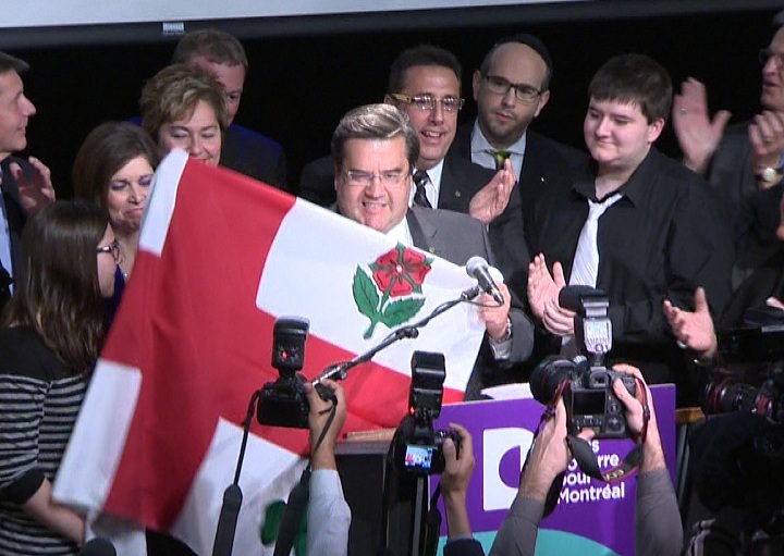 Montreal mayor Denis Coderre holds the flag for the city.