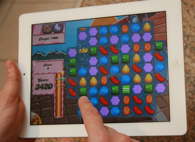 A man plays the computer game "Candy Crush Saga" on his iPad.