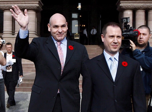 George Smitherman, left, and his husband Christopher Peloso wave as they leave Queens's Park on Monday, Nov. 9, 2009 in Toronto. 