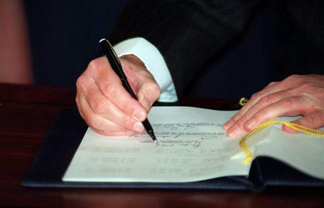 Prime Minister Brian Mulroney signs the North American Free Trade Agreement during a signing ceremony in Ottawa, Dec.17, 1992. 