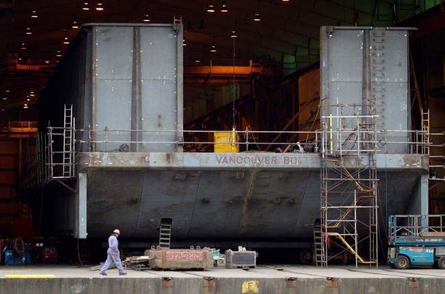 File photo - A Seaspan Vancouver Shipyards worker walks past a barge under construction on Wednesday November 2, 2011.