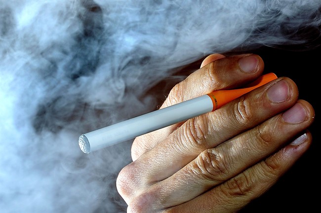 A person holds an electronic cigarette, or e-cigarette,.