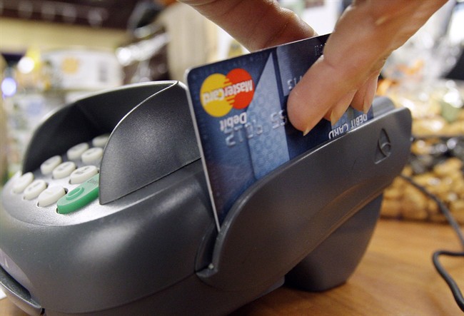 In this Nov. 2, 2009 photo, a customer swipes a debit card through a point-of-sale machine.